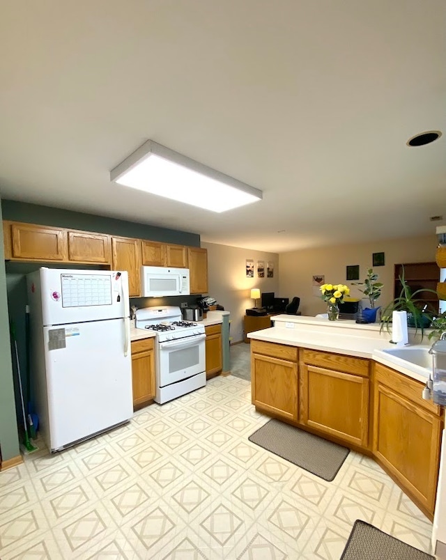 kitchen featuring white appliances and kitchen peninsula