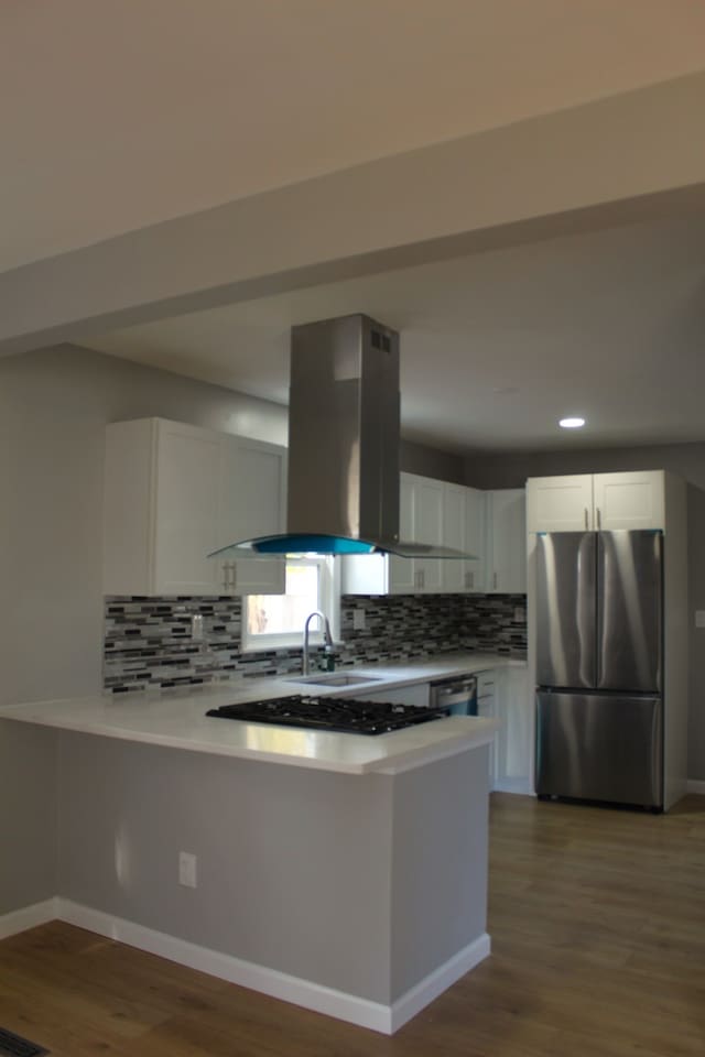 kitchen featuring white cabinetry, island range hood, light countertops, and freestanding refrigerator