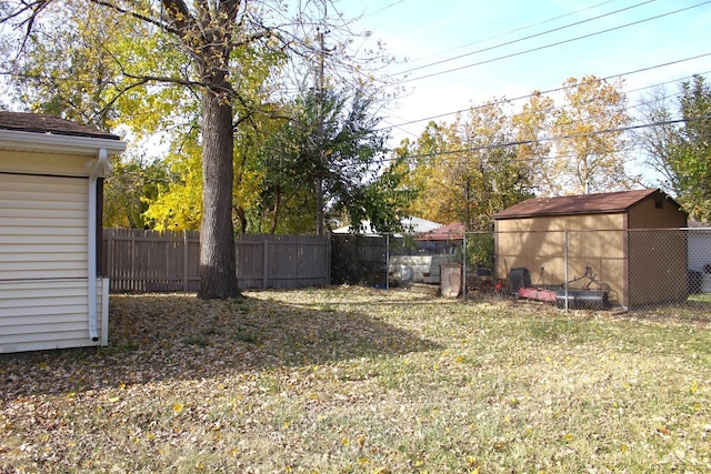 view of yard with an outbuilding, a storage unit, and a fenced backyard