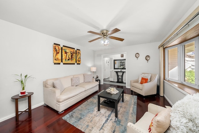 living room featuring dark wood-type flooring and ceiling fan