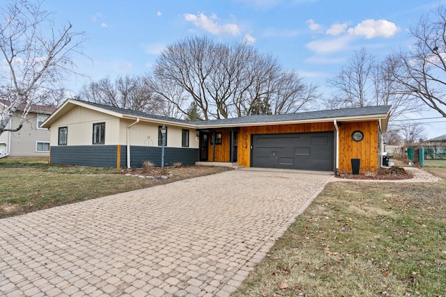 single story home featuring a garage and a front yard