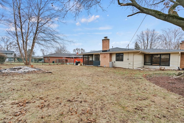 back of house featuring a yard and a sunroom