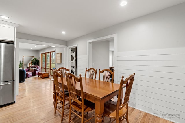 dining space featuring light wood-type flooring and stacked washer and dryer