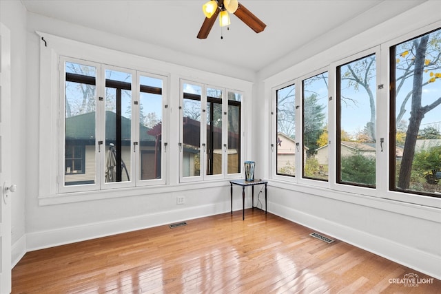 unfurnished sunroom with ceiling fan