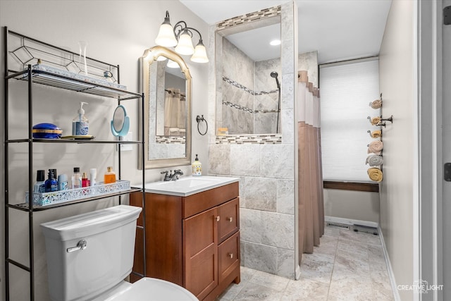 bathroom featuring toilet, vanity, and a tile shower