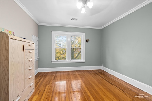 empty room featuring ceiling fan, hardwood / wood-style flooring, and ornamental molding