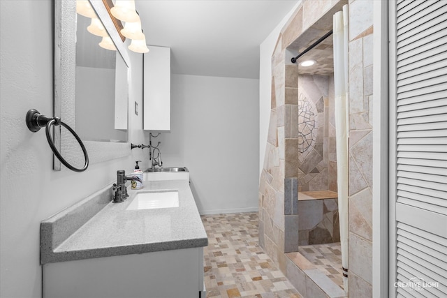 bathroom with vanity and a tile shower