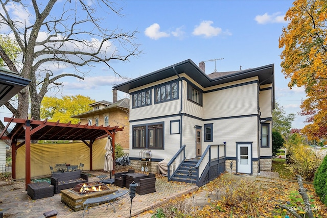 back of property with an outdoor living space with a fire pit, a patio area, and a pergola