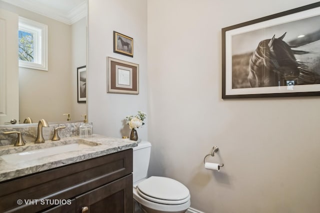 bathroom with vanity, crown molding, and toilet