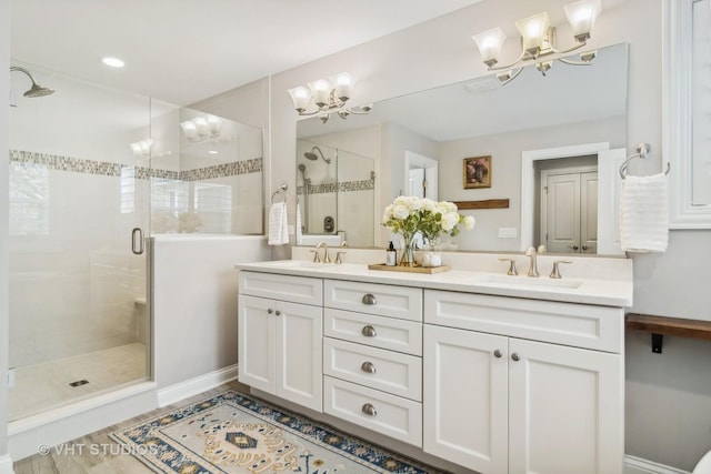 bathroom featuring an inviting chandelier, vanity, and an enclosed shower