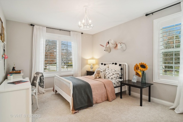 bedroom featuring light colored carpet and a notable chandelier