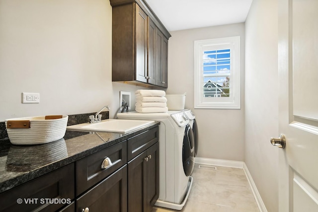 laundry area featuring washer and dryer, sink, light tile patterned floors, and cabinets