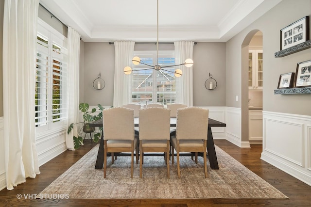 dining area with a notable chandelier, crown molding, and dark wood-type flooring