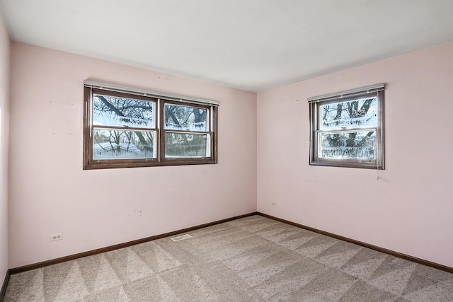 unfurnished room with plenty of natural light and light carpet