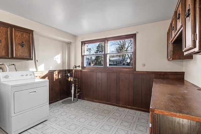 laundry area featuring cabinets, wood walls, and washer / dryer