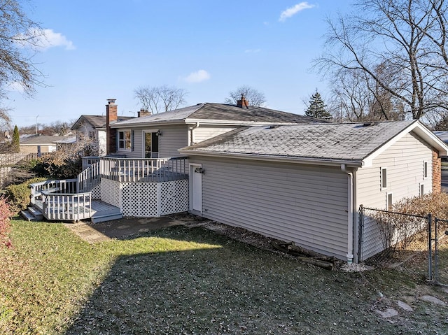 rear view of house with a yard and a wooden deck