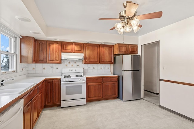 kitchen featuring ceiling fan, white appliances, sink, and tasteful backsplash