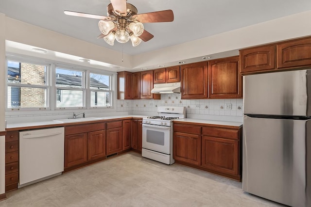 kitchen featuring white appliances, tasteful backsplash, ceiling fan, and sink