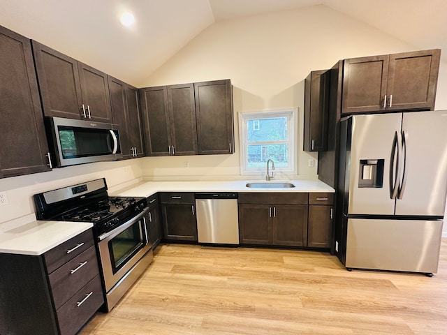 kitchen with stainless steel appliances, sink, high vaulted ceiling, dark brown cabinets, and light hardwood / wood-style flooring