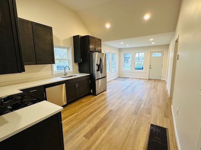 kitchen featuring appliances with stainless steel finishes, lofted ceiling, a healthy amount of sunlight, and sink