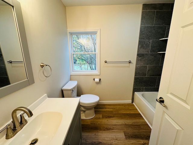 full bathroom featuring wood-type flooring, vanity, toilet, and tiled shower / bath combo