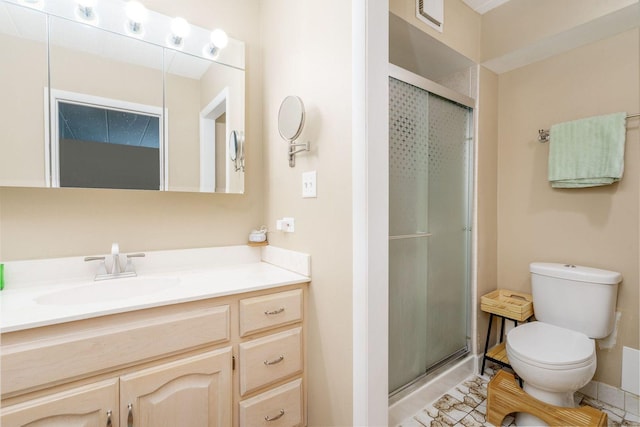 bathroom featuring a shower with shower door, vanity, and toilet