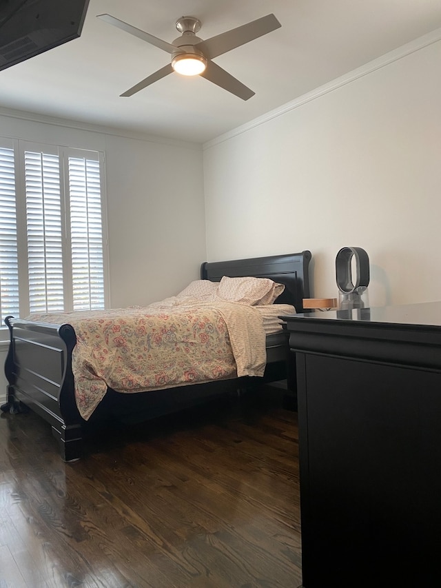 bedroom with dark wood-type flooring, ceiling fan, and crown molding