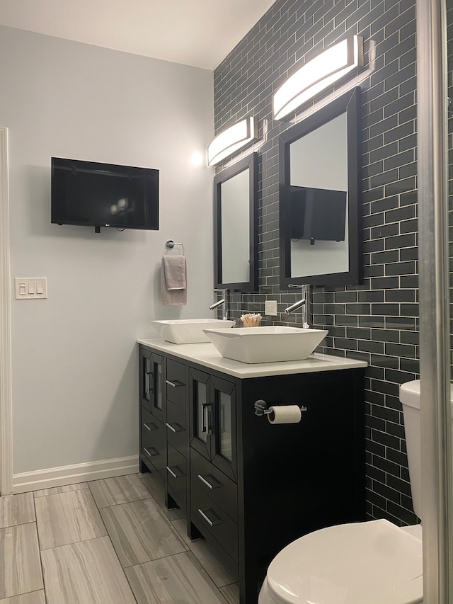 bathroom featuring vanity, toilet, and tile walls