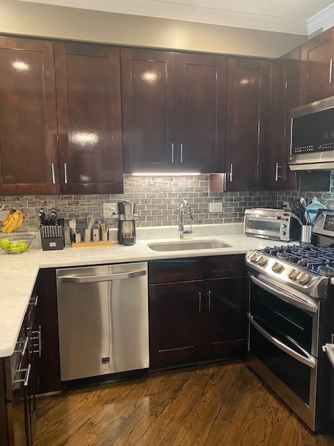 kitchen with stainless steel appliances, decorative backsplash, sink, and dark hardwood / wood-style floors