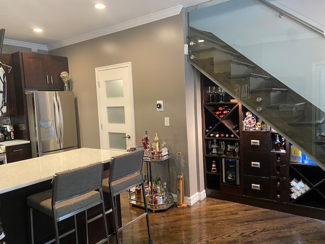 wine cellar featuring dark wood-type flooring and ornamental molding