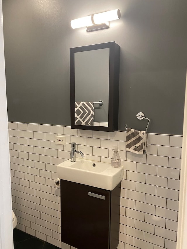 bathroom featuring tile walls, vanity, and toilet