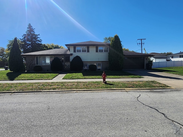 split level home with a garage and a front yard