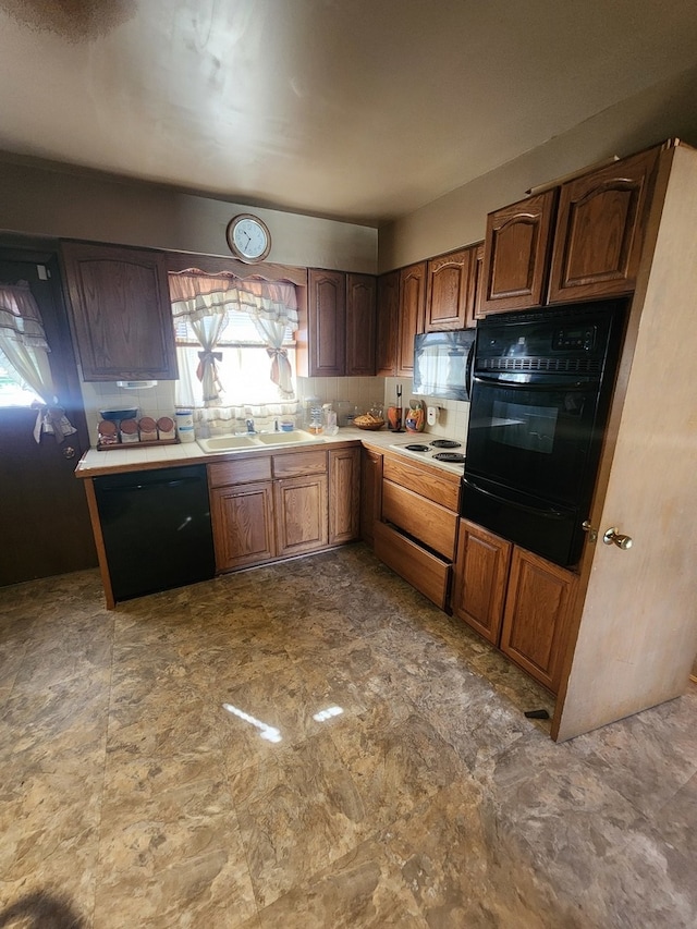 kitchen with black appliances, decorative backsplash, and sink