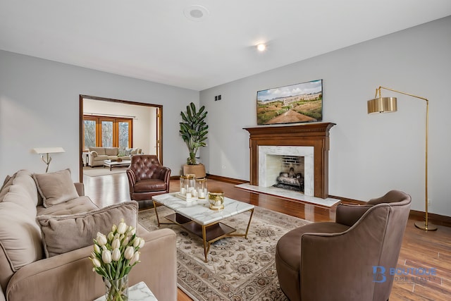 living room with hardwood / wood-style floors and a premium fireplace