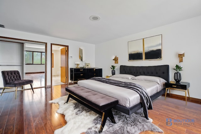 bedroom featuring hardwood / wood-style flooring and ensuite bath