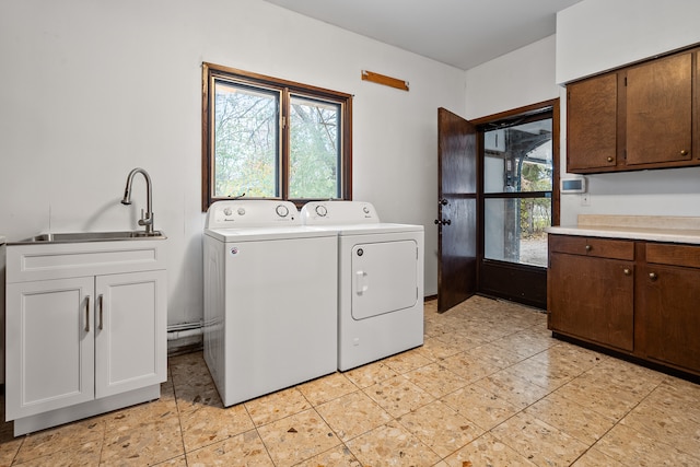 laundry area with washing machine and clothes dryer, sink, and cabinets