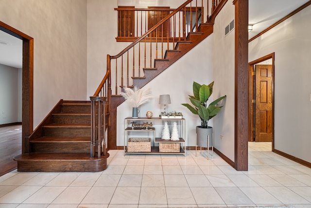 stairway featuring tile patterned floors and a high ceiling