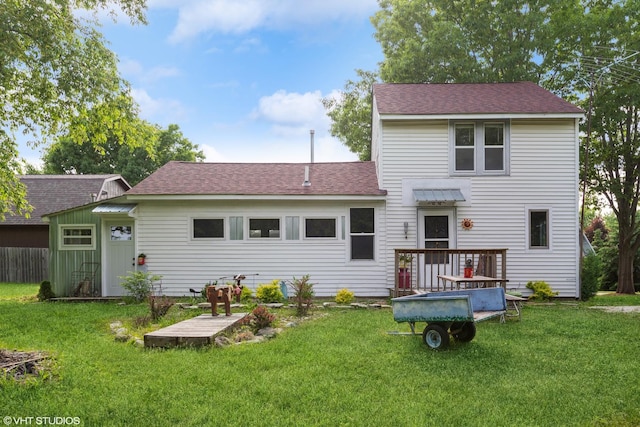 back of property featuring a wooden deck and a yard