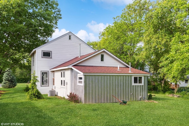 rear view of house with a yard and cooling unit