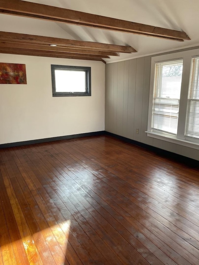 empty room with dark hardwood / wood-style floors and beam ceiling