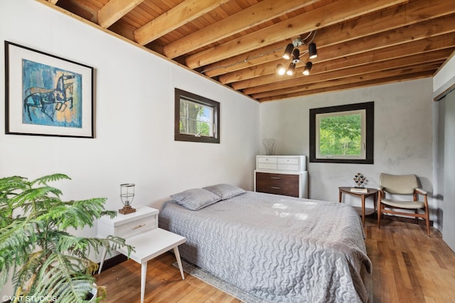 bedroom featuring beam ceiling, wood-type flooring, and wooden ceiling