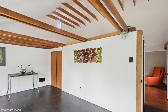 living room featuring beamed ceiling and dark wood-type flooring