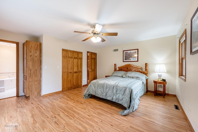 bedroom with ceiling fan, light wood-type flooring, connected bathroom, and two closets