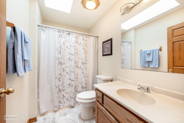 bathroom featuring walk in shower, a skylight, vanity, and toilet