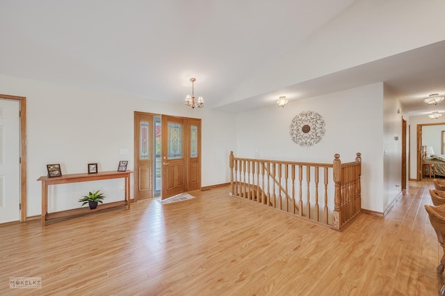 foyer entrance featuring light hardwood / wood-style floors and a notable chandelier