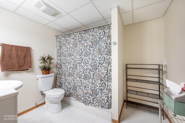 bathroom featuring a paneled ceiling, tile patterned floors, radiator, vanity, and toilet