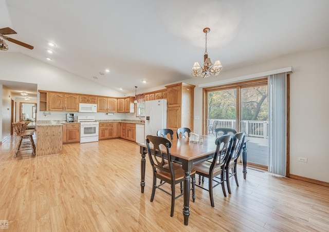 dining room with light hardwood / wood-style flooring, ceiling fan with notable chandelier, and vaulted ceiling