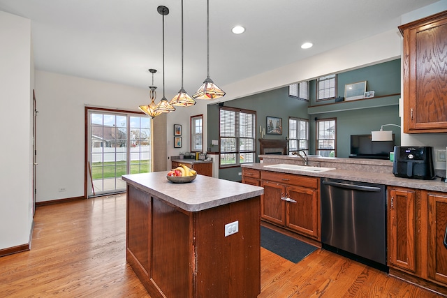 kitchen featuring a wealth of natural light, dishwasher, sink, and a kitchen island