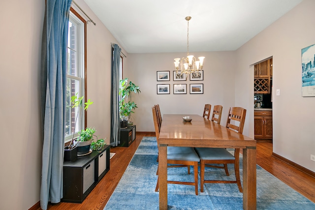 dining area with a chandelier, a wealth of natural light, and dark hardwood / wood-style floors