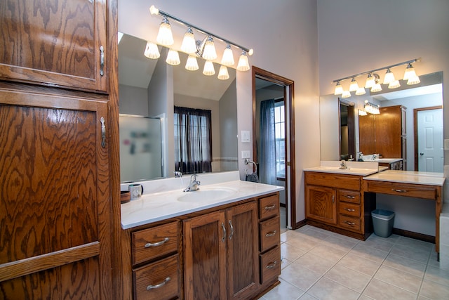 bathroom featuring vanity, walk in shower, tile patterned flooring, and lofted ceiling